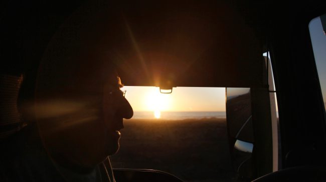 Semi truck driver with a sunset